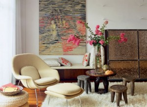 A living room with a large textured painting on the wall.