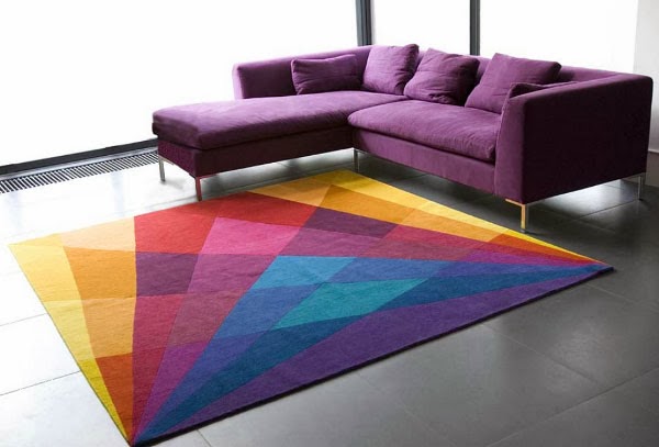 An on-trend interior design with a colorful rug in a living room featuring a purple couch.