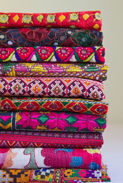 A colorful stack of fabrics with a global chic essence.