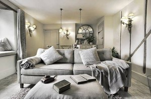 A living room with gray interiors featuring a couch and a lamp.