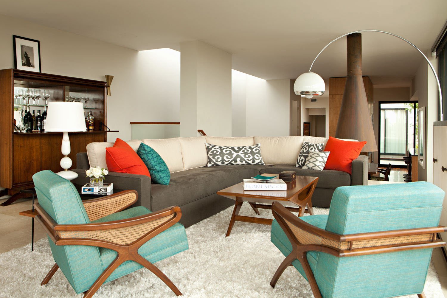 A living room with a 70s retro style, featuring a couch, chairs, and a coffee table.