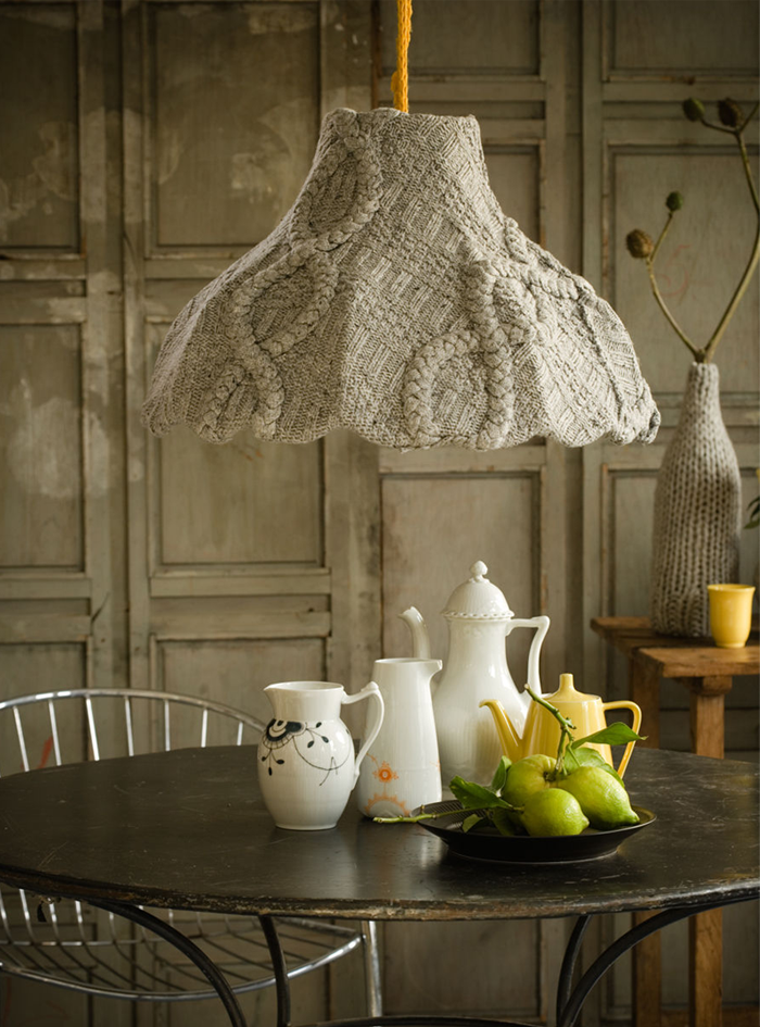 A table with a lamp hanging over it, using knits in your home décor.