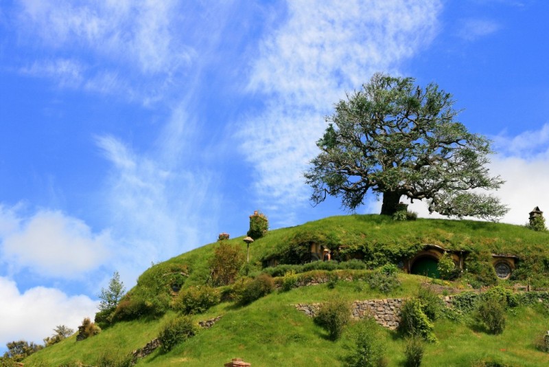 A green hill features a hobbit house.