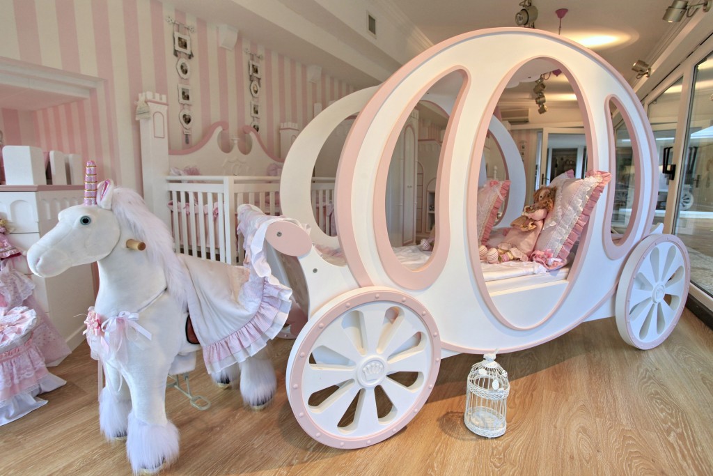 A girl's bedroom with a pink cot.