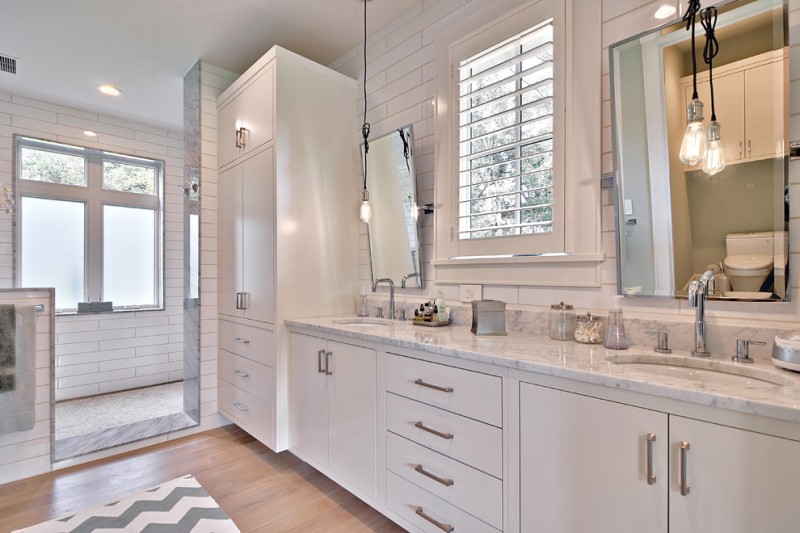 A bathroom with white cabinets features 4 eccentric ways to light your space.