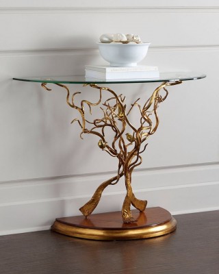 A gold console table with a spring tree on top.