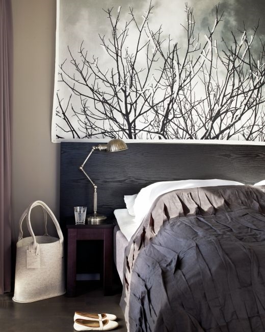 A black and grey bedroom with a large painting on the wall featuring Norwegian home decor.