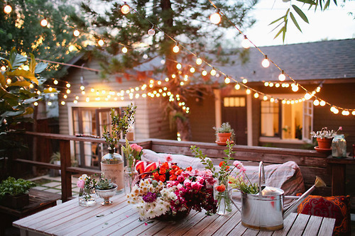 A backyard dining table with flowers on it.