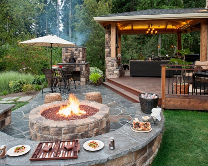 A backyard with a fire pit and patio furniture transformed into an outdoor kitchen.