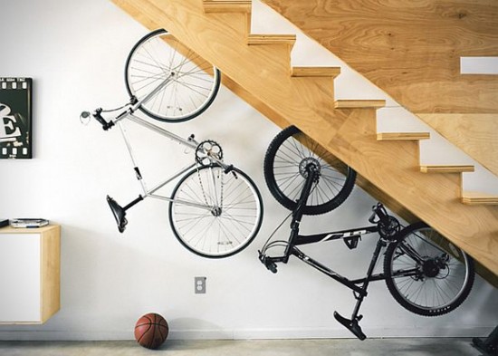 A bicycle is hanging under the stairs, serving as storage.