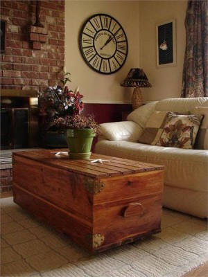 A living room with a alternative wooden trunk coffee table.