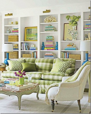 A living room with green and white furniture and bookshelves, inspired by spring.