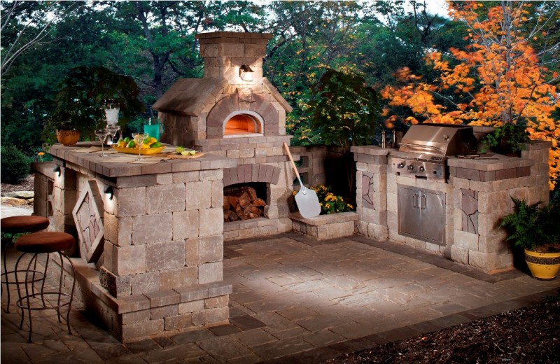 A stone patio with an outdoor kitchen.