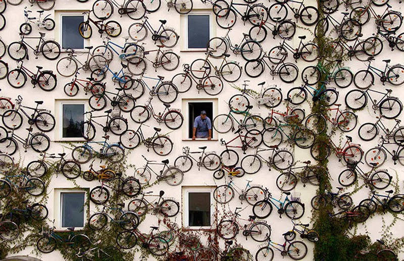 A building showcasing an array of upcycled bicycles.