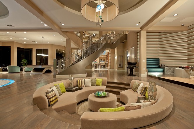A circular living room with sunken seating and a staircase.