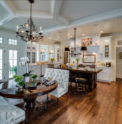 A traditional kitchen with hardwood floors and a dining table.