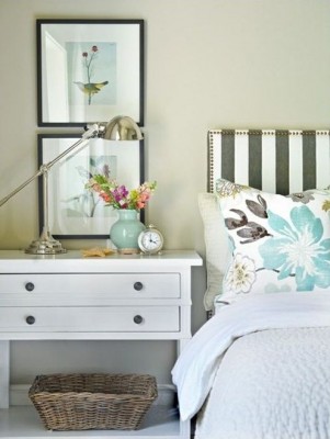 A white and blue bedroom with a bed and a bedside table.