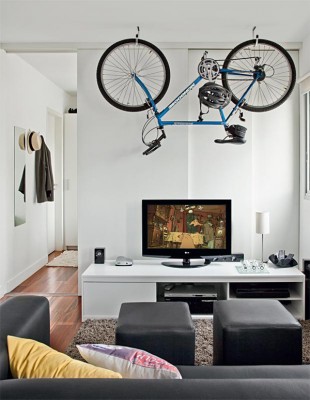 A living room with a bicycle serving as unique storage decoration.
