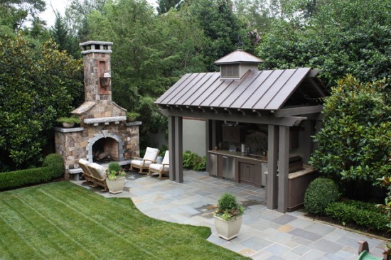 This outdoor kitchen design is charming and includes a sitting area by the fireplace (houzz)