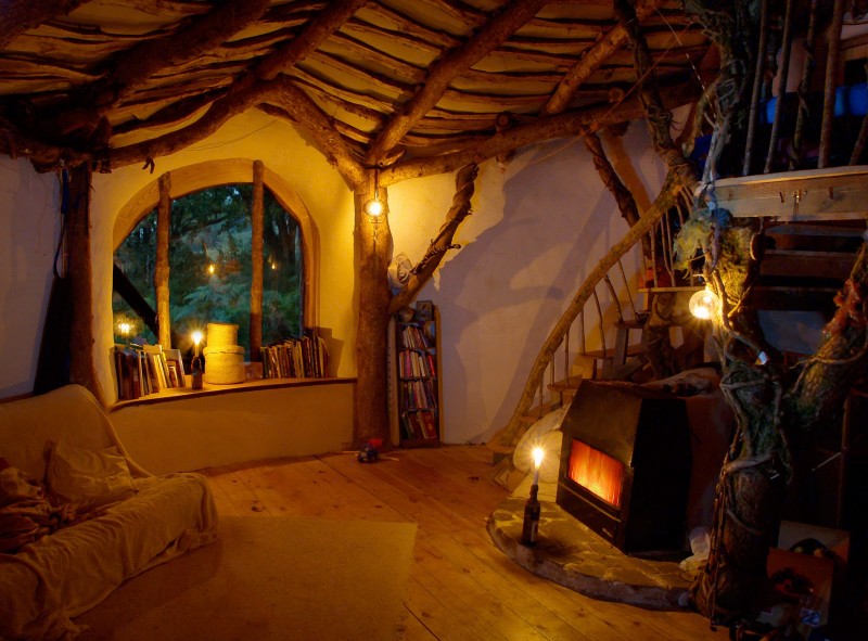A hobbit house with a fireplace in the living room.