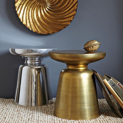 A pair of gold side tables on a spring-themed rug.