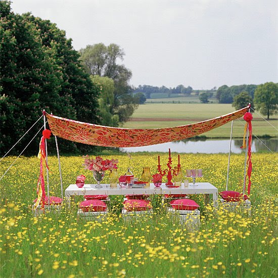 A table is set up for backyard dining in a field of yellow flowers.