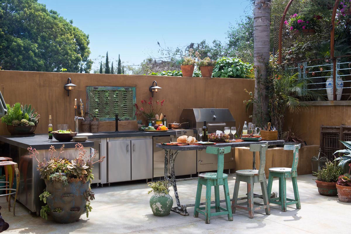 An outdoor kitchen with potted plants.