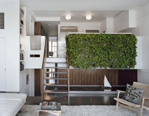 A living room with unexpected features like a green wall and stairs.