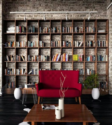 A home library with bookshelves and a red couch.