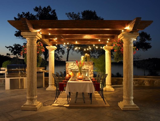 Backyard dining area with a pergola and lights.
