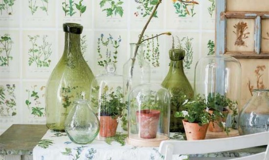 A table with spring-themed vases and potted plants on it.