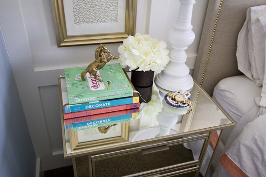 Styling a bedside table with books and a lamp.