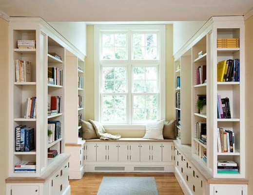 A cozy home library filled with bookshelves and a window.
