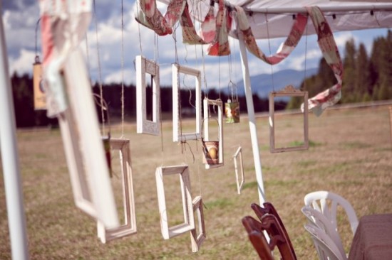 A table and chairs are suspended from string in a field.