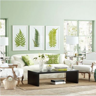 A living room with green walls and white furniture, perfect for the spring season.