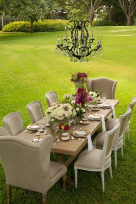 A backyard dining table set in a grassy field.