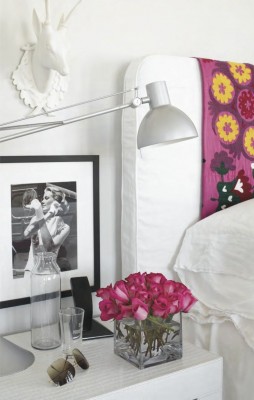Tips for choosing and styling a bedside table with a vase of flowers and a lamp.