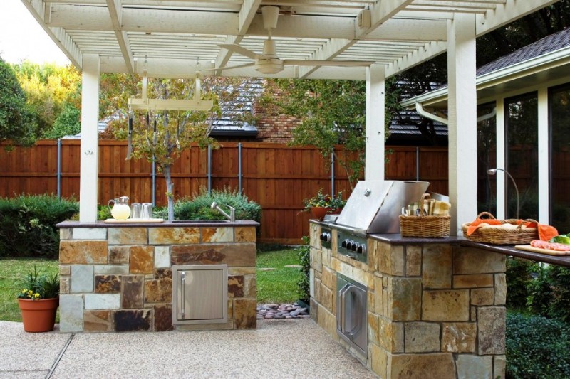 An outdoor kitchen with stone counter tops.