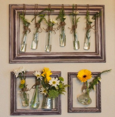 A group of picture frames with flowers in them hanging on a wall.
