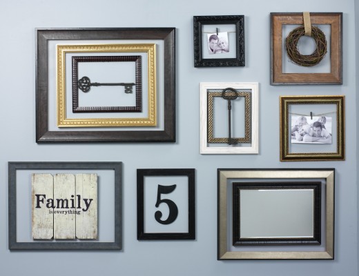 A wall adorned with multiple picture frames and a key.