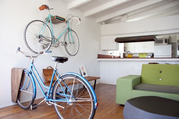 A bicycle is hung on the wall in a living room for storage.