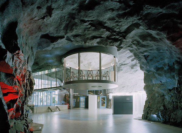 A unique creative office space resembling the interior of a cave with a circular staircase.