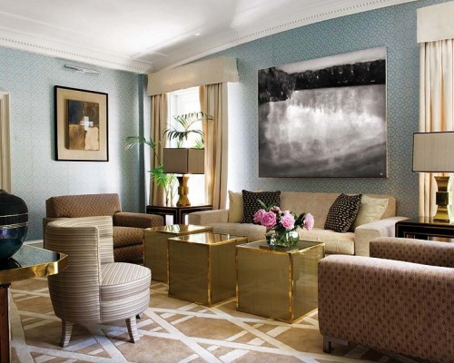 A living room with blue walls and gold accents, perfect for spring.