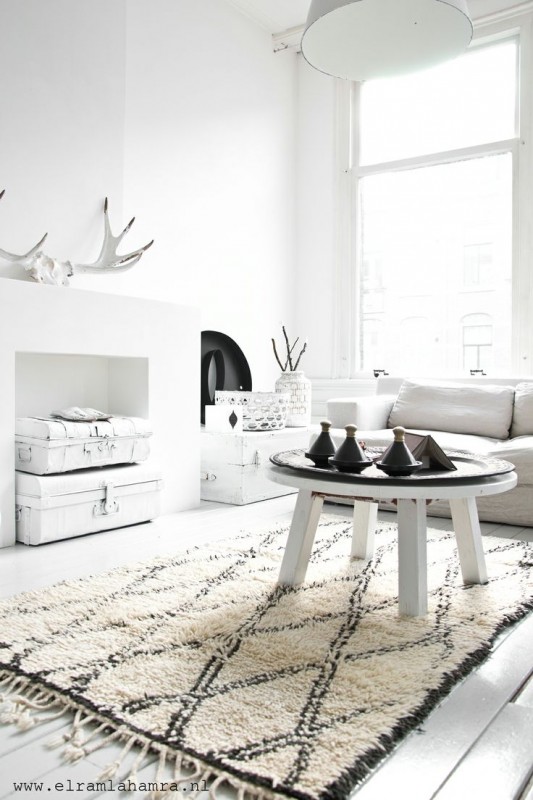 A living room with white walls and a rug, inspired by Norwegian home decor.