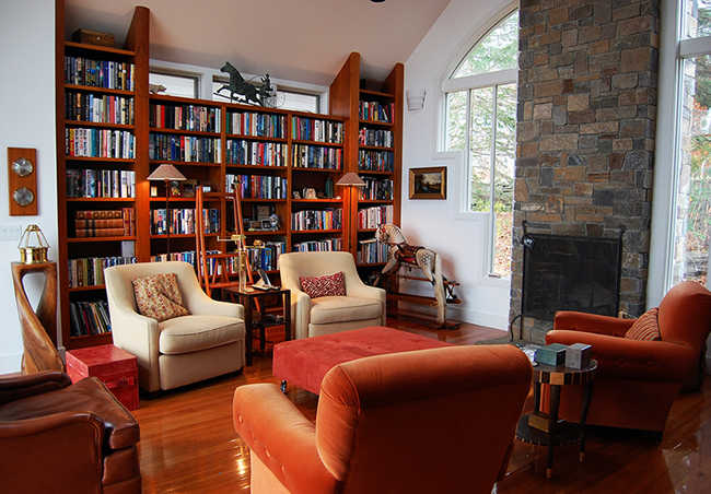 A home library with bookshelves and a fireplace.