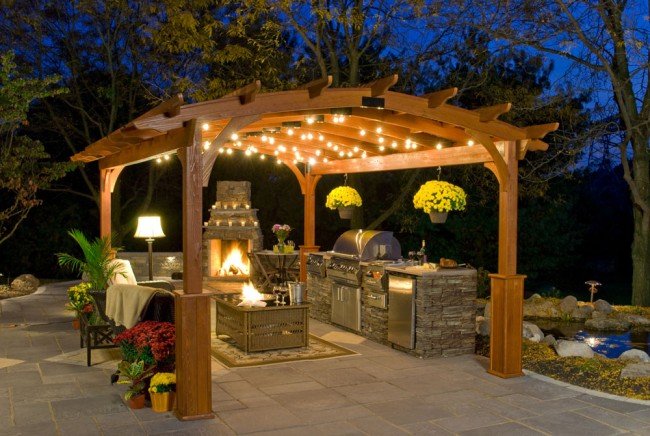 A wooden pergola with a fire pit and grill, perfect for backyard entertaining.