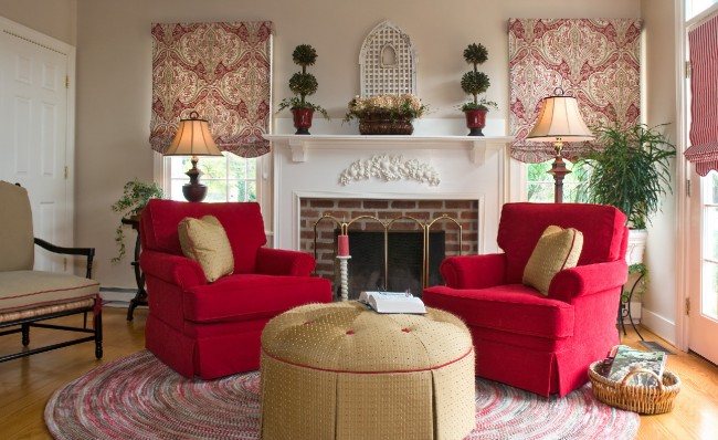 A living room with red chairs and a fireplace showcasing the basics of interior design.