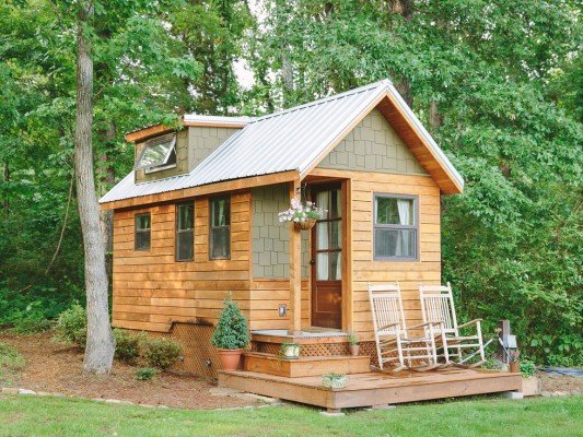 A tiny house nestled in a wooded area, perfect for sustainable living.