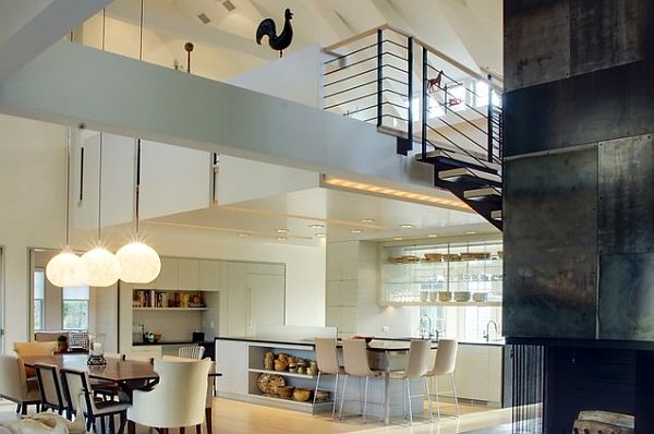 A modern loft space with a kitchen, dining room, and staircase.