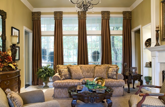 A living room with furniture and a fireplace featuring window treatments.